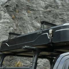 Roof top tent attached to a car with a natural elements logo on a textured background