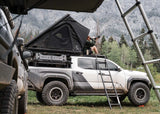 Backwoods Adventure Mods DRIFTR Roof Rack (2024–2027 Tacoma) — Lifestyle shot: Tacoma on the trail with the loaded rack