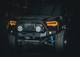 Backwoods Adventure Mods Hi-Lite Bull Bar (2016–2023 Tacoma) — Lifestyle shot: black Tacoma with a winch mounted in the bull bar bumper