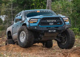 Backwoods Adventure Mods Hi-Lite Bull Bar (2016–2023 Tacoma) — Lifestyle shot: blue Tacoma with the bull bar bumper on a dirt trail