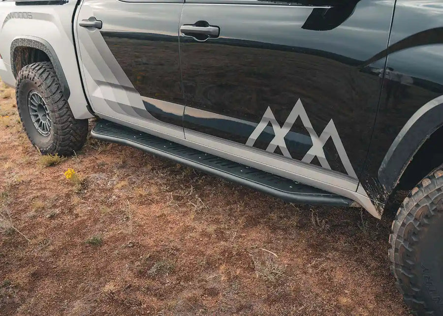 Backwoods Adventure Mods Rock Sliders (2022–2025 Tundra) — Lifestyle shot: sliders installed on a 3rd gen Tundra parked on the trail