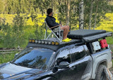 Backwoods Adventure Mods DRIFTR Roof Rack (2022–2027 Tundra) — Lifestyle shot: relaxing in a camp chair on the deck panels