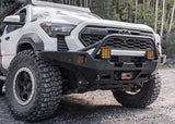 Backwoods Adventure Mods Hi-Lite Prerunner (2024–2027 Tacoma) — Lifestyle shot: white Tacoma with the prerunner bumper and a winch installed