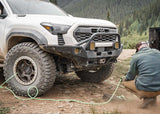 Backwoods Adventure Mods Hi-Lite Prerunner (2024–2027 Tacoma) — Lifestyle shot: airing down tires at the trailhead with the prerunner bumper fitted