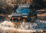 Backwoods Adventure Mods Hi-Lite Bull Bar (2010–2024 4Runner) — Lifestyle shot: white 4Runner with a winch crossing water off road