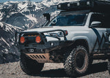 Backwoods Adventure Mods Hi-Lite Bull Bar (2010–2024 4Runner) — Lifestyle shot: white 4Runner with the bull bar bumper driving through the mountains