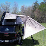 OVS HD Bushveld 4 Tent Awning — Lifestyle shot: Bushveld tent awning shading a Jeep camp in a forest clearing. Instant shade off the tent door for families camping out of a hard shell
