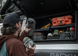 Backwoods Adventure Mods Bed Rack Storage Box (2005–2027 Tacoma) — Lifestyle shot: camp pillow and hammock stowed in the box
