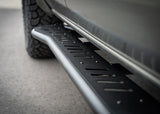 Backwoods Adventure Mods Rock Sliders (2024–2027 Tacoma) — Feature shot: front end of the slider behind the front tire