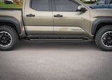 Backwoods Adventure Mods Rock Sliders (2024–2027 Tacoma) — Feature shot: full side view of a 4th gen Tacoma with the sliders