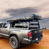 OVS Discovery Bed Rack – Mid-Size Truck Short Bed — Lifestyle shot: rack with rooftop tent on a Toyota Tacoma at a desert camp; rooftop tent, awning and recovery gear carried above the bed for multi-day trips.