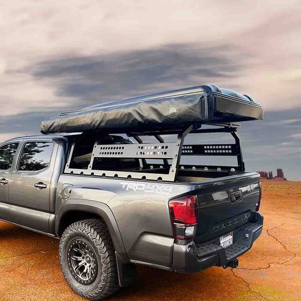 OVS Discovery Bed Rack – Mid-Size Truck Short Bed — Lifestyle shot: rack with rooftop tent on a Toyota Tacoma at a desert camp; rooftop tent, awning and recovery gear carried above the bed for multi-day trips.