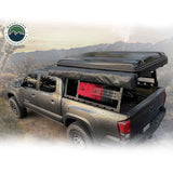 OVS Discovery Bed Rack – Mid-Size Truck Short Bed — Lifestyle shot: Tacoma with the rack and a deployed tent in the mountains; rooftop tent, awning and recovery gear carried above the bed for multi-day trips.