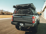 GateKEEPER — Lifestyle shot: Ford Super Duty with rooftop tent and loaded bed rack, GateKEEPER closed across the rear securing gear for the road.