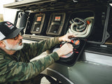 GearBAG G2 3-Pack — Lifestyle shot: a driver pulls the mesh interior pouch from a GearBAG mounted in the GearPOD XL, kinetic recovery rope stowed alongside it.