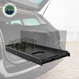 OVS Heavy-Duty Fridge Slide — Lifestyle shot: installed and in use; a fridge within easy reach at the tailgate.