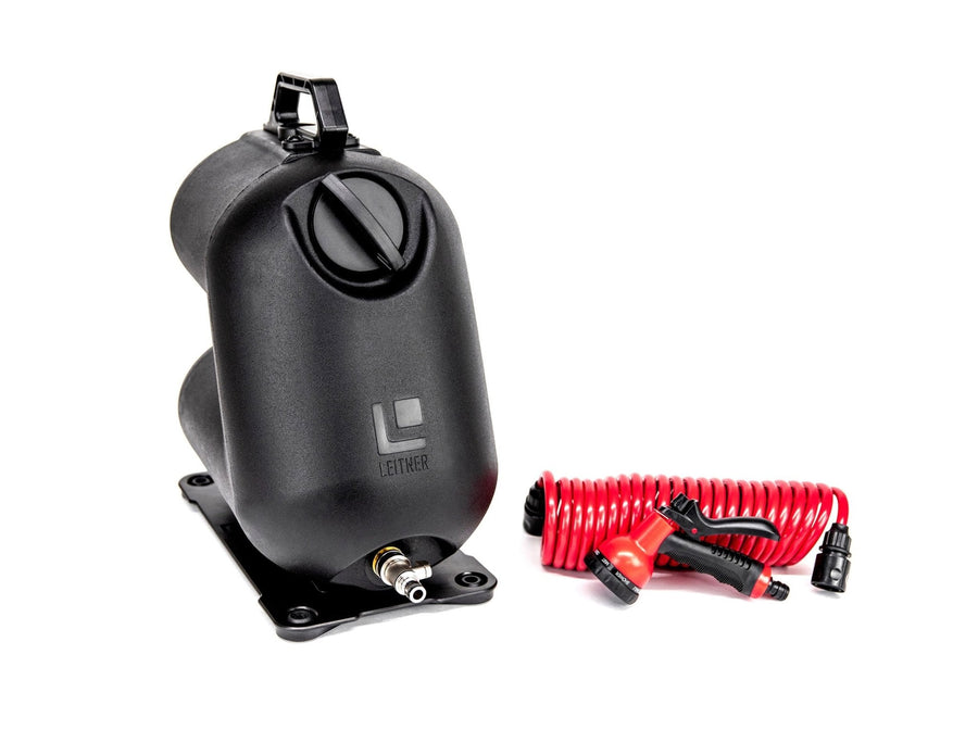 HydroPOD CARRY Portable Shower Kit — Feature shot: black free-standing tank unit with integrated hand pump handle, mounting base, and 20-foot coiled hose with spray nozzle, studio product shot.