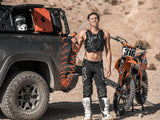 HydroPOD ACS RACK Shower Kit — Lifestyle shot: a dirt bike rider rinses off dust and sweat trailside using the hose from the rack-mounted tank next to his bike.