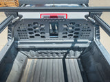 HeadBANGER — Lifestyle shot: straight-down bed view of a GMC AT4X with the guard installed beneath a rack-mounted brake light bar.