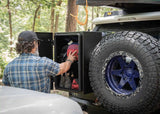 Backwoods Adventure Mods Overland Storage Box (Universal) — Lifestyle shot: hiker pulling gear from the storage box