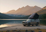 Roofnest Falcon 3 EVO XL Air — Lifestyle shot: open tent on a 4Runner at a mountain lake at sunrise. Roomy basecamp for a couple or small family on a full-size SUV.