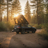Roofnest Falcon 3 EVO Air — Lifestyle shot: open tent on a Subaru in a pine forest at golden hour. Easy two-person camping on a smaller vehicle.