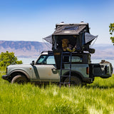 Side profile of a Ford Bronco carrying the OVS XD Atlas rooftop tent by a mountain lake