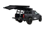 FSR 180 Tailgate Awning — Lifestyle shot: deployed at the rear of a black Toyota Tacoma overlanding setup
