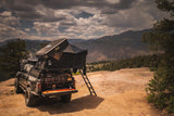 FSR Kali — Lifestyle shot: rear view of an overlanding Tacoma with the Kali mounted, dirt campsite and forested mountains
