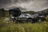 FSR Kali — Lifestyle shot: two Tacomas with Kali tents deployed in a grassy field with mountains