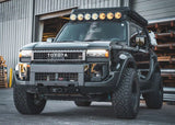Backwoods Adventure Mods Lo-Pro Hidden Winch Bumper (2024–2027 Land Cruiser 250) — Lifestyle shot: black 2025 Land Cruiser 250 set up for off-roading