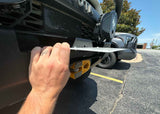Backwoods Adventure Mods Flip-Up License Plate Holder (Hawse Fairlead) — Feature shot: hand lifting the plate to reach the winch line