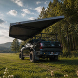 NaturNest 180° Car Awning — Feature shot: rear view of the deployed awning showing the aluminum frame and canvas panel