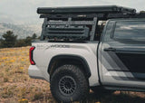 Backwoods Adventure Mods Overland Bed Rack Full Height (2007–2027 Tundra) — Lifestyle shot: white 3rd gen Tundra with a tent and traction boards on the rack